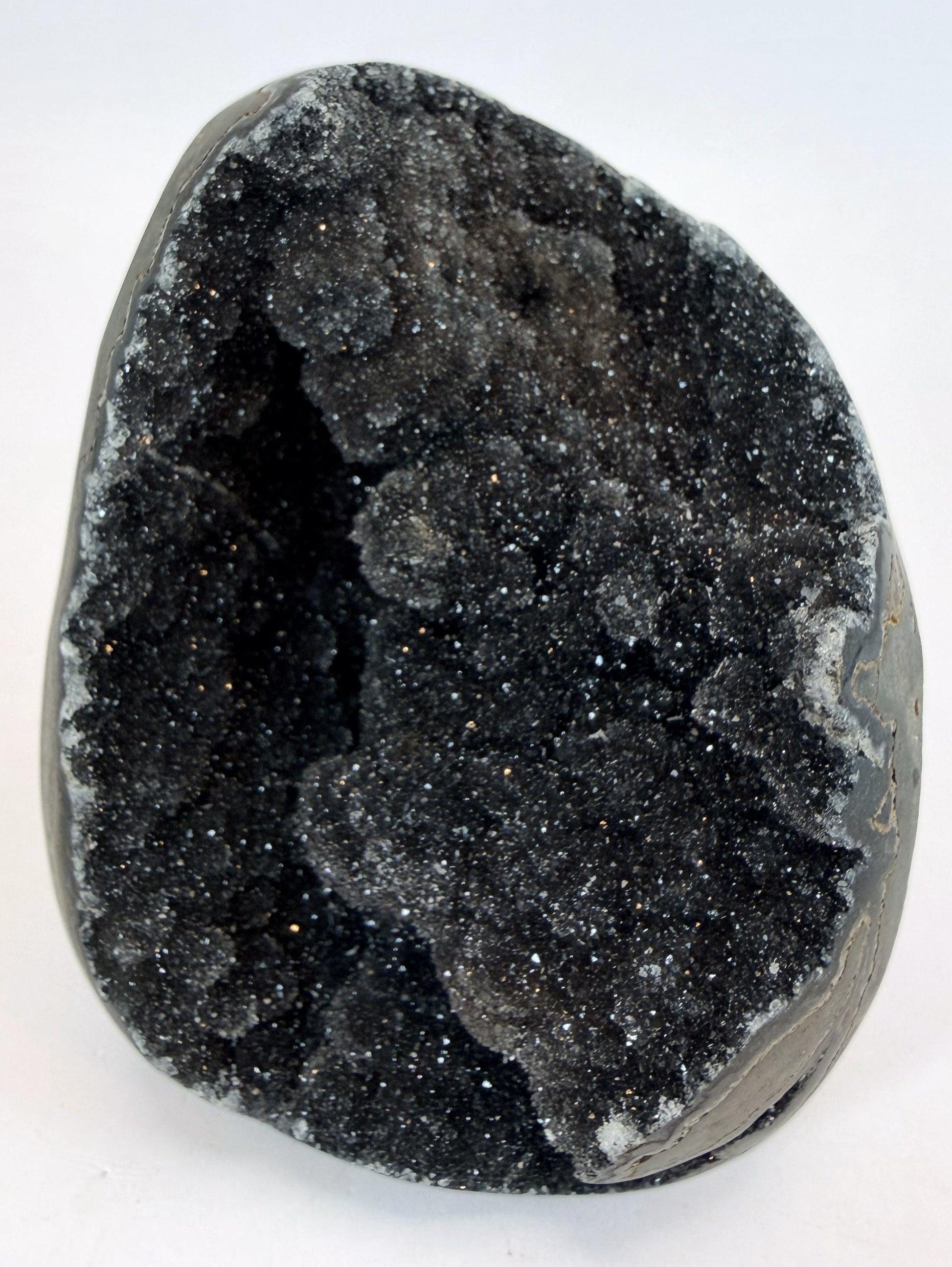 Black druzy quartz geode, front view of the sparkling crystal cave