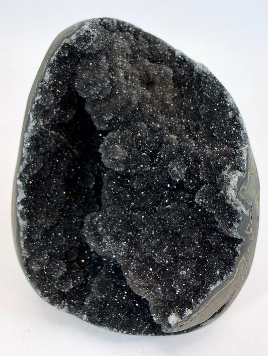 Black druzy quartz geode, front view of the sparkling crystal cave