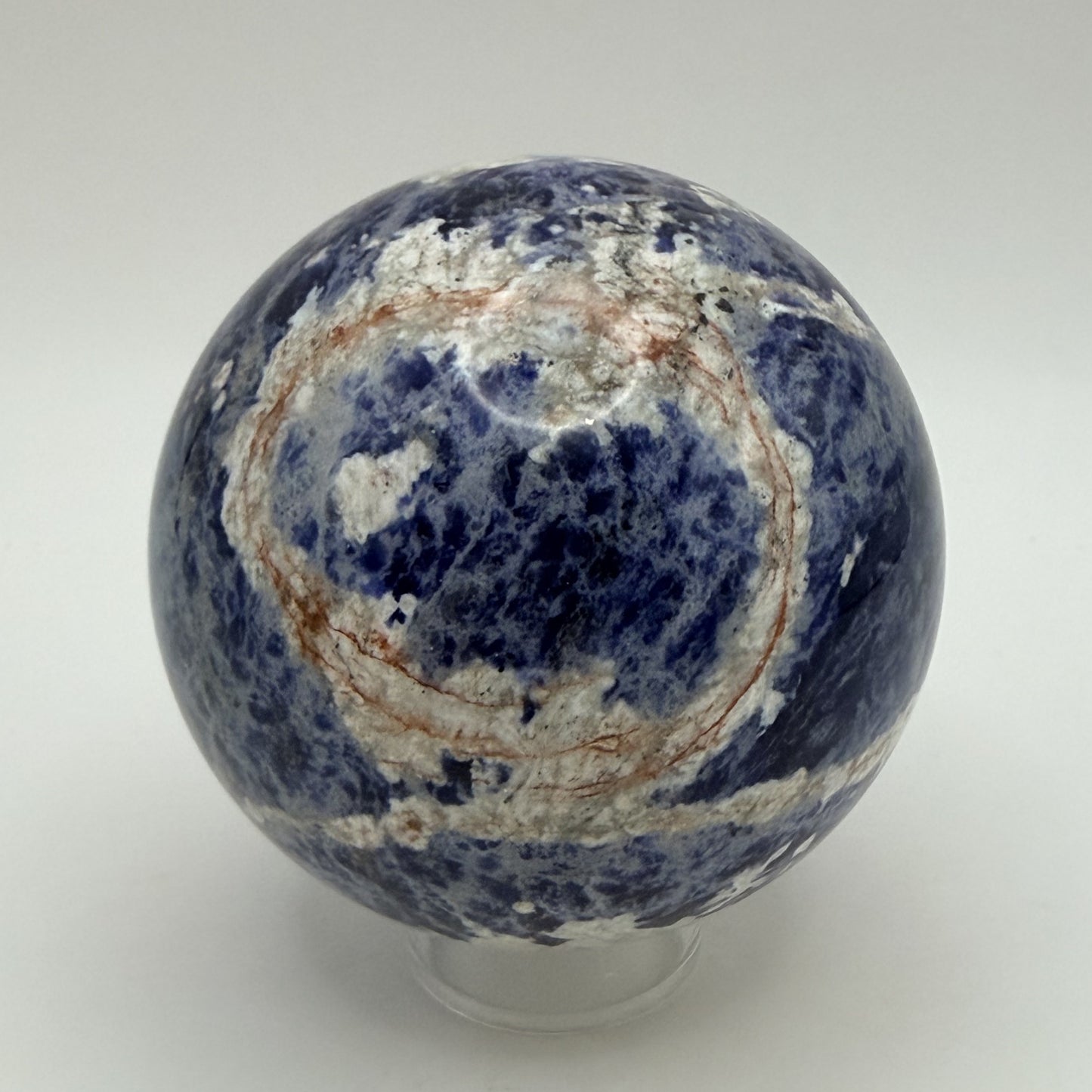 Sunset Sodalite sphere showing the rust orange ring