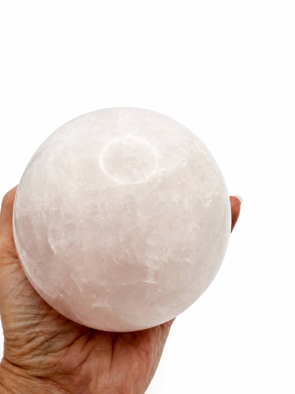 Rose Quartz Sphere held in hand showing size