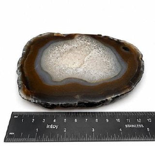 Natural agate slice with druzy quartz center and amber banding on acrylic stand
