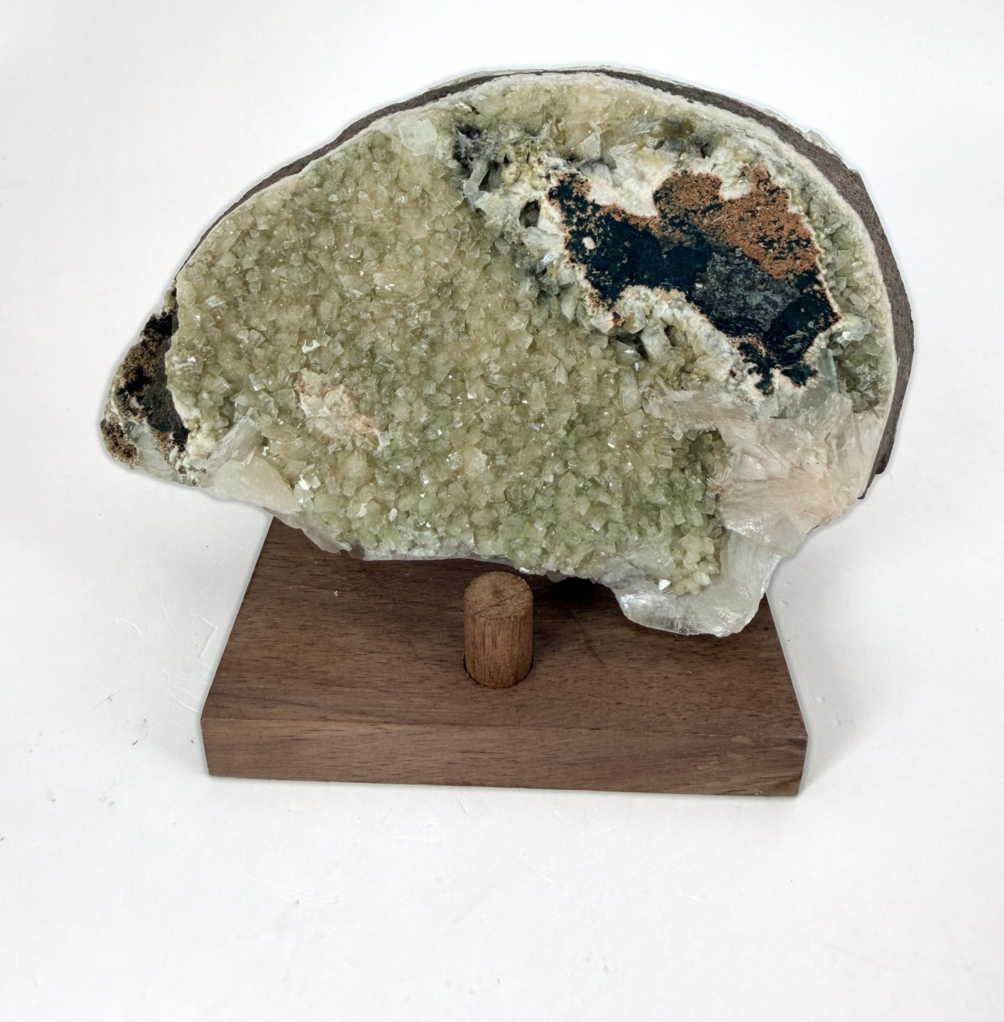 Green apophyllite with peach stilbite on a wood stand