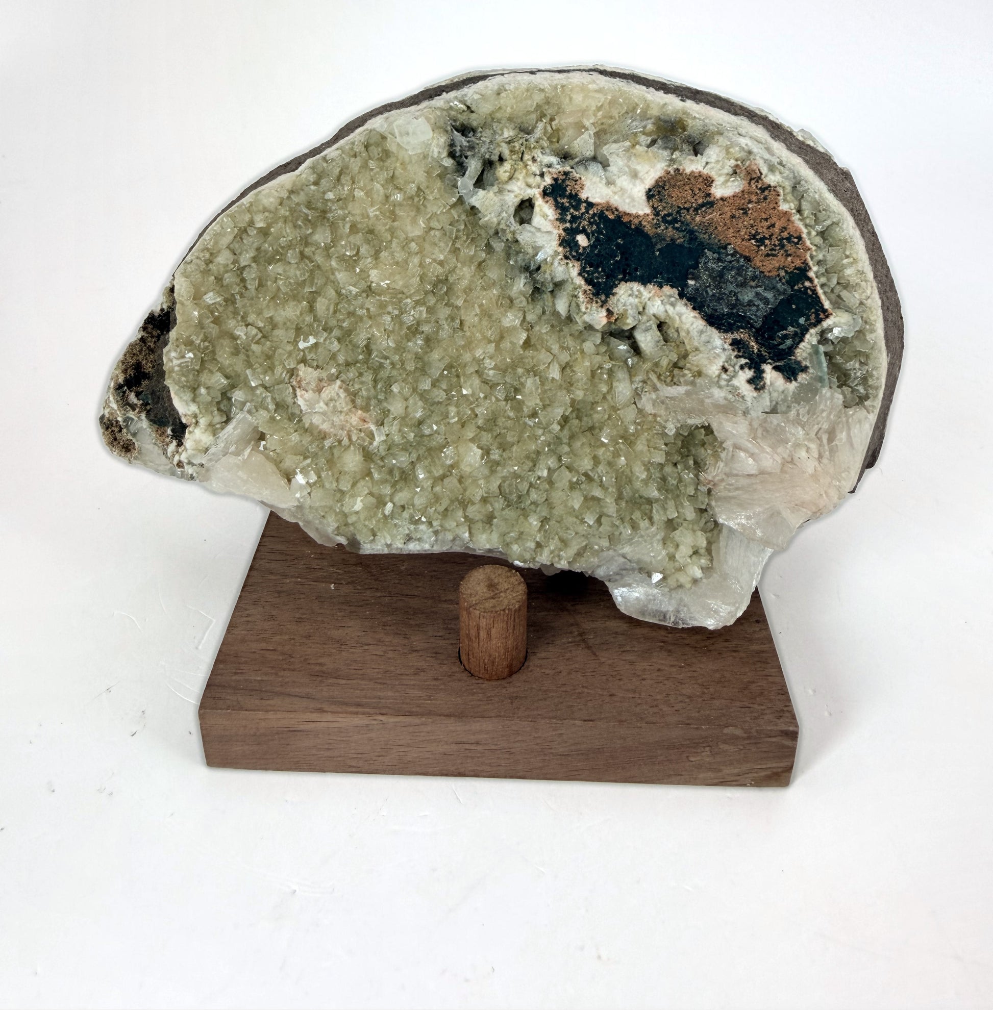 Green apophyllite with peach stilbite on a wood stand