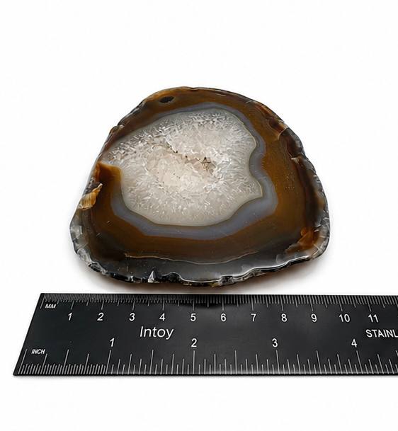 Natural agate slice with druzy quartz center and amber banding on acrylic stand