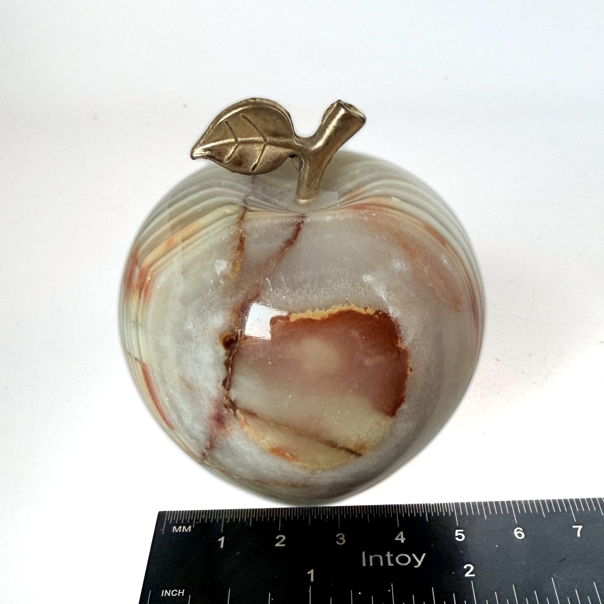 Onyx apple beside a ruler showing width