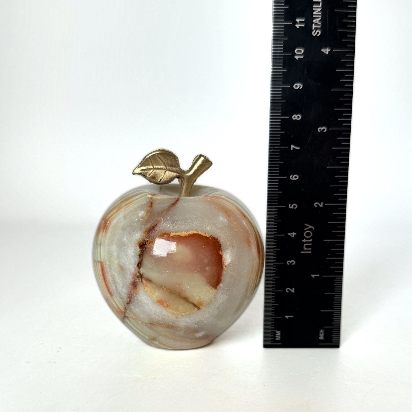 Onyx apple beside a ruler showing height
