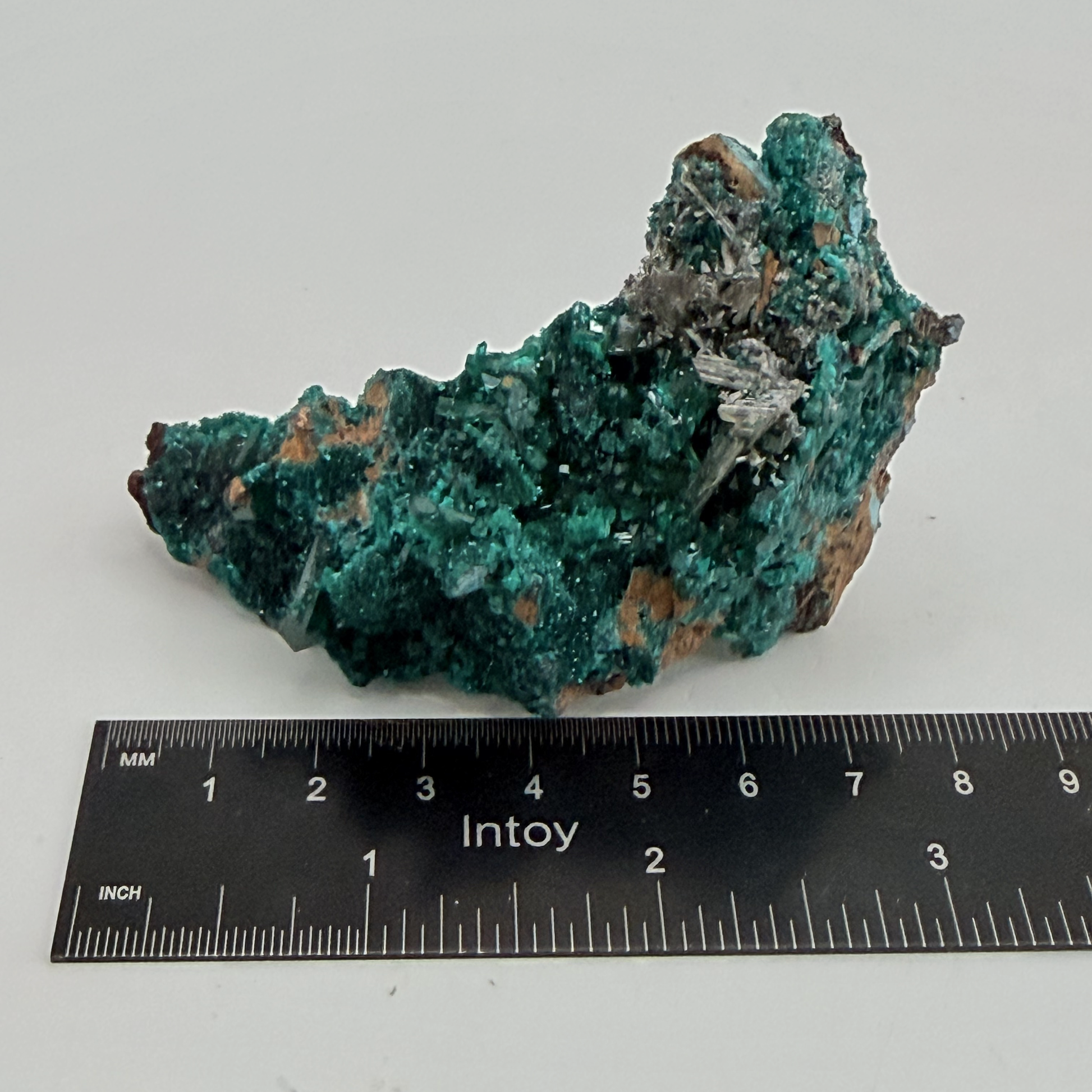 Dioptase specimen with silvery blades