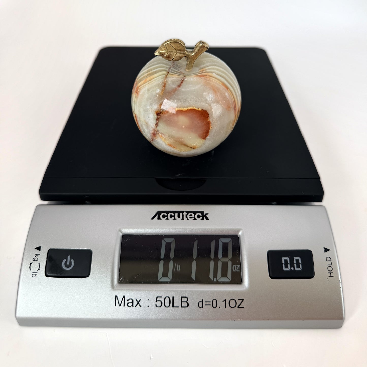 Onyx apple on a scale reading 11.8 ounces