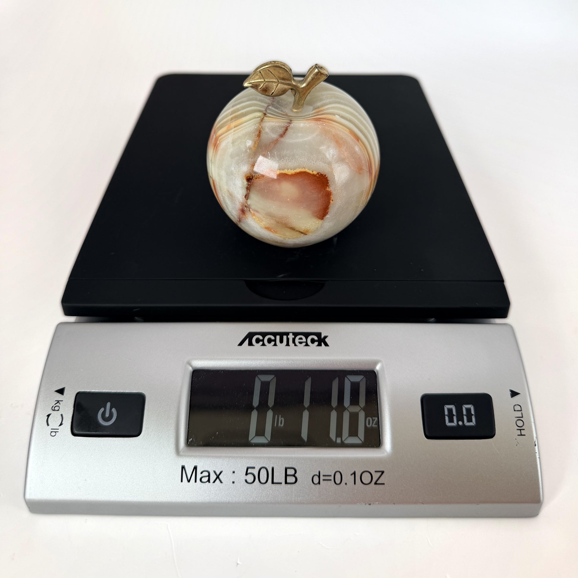 Onyx apple on a scale reading 11.8 ounces