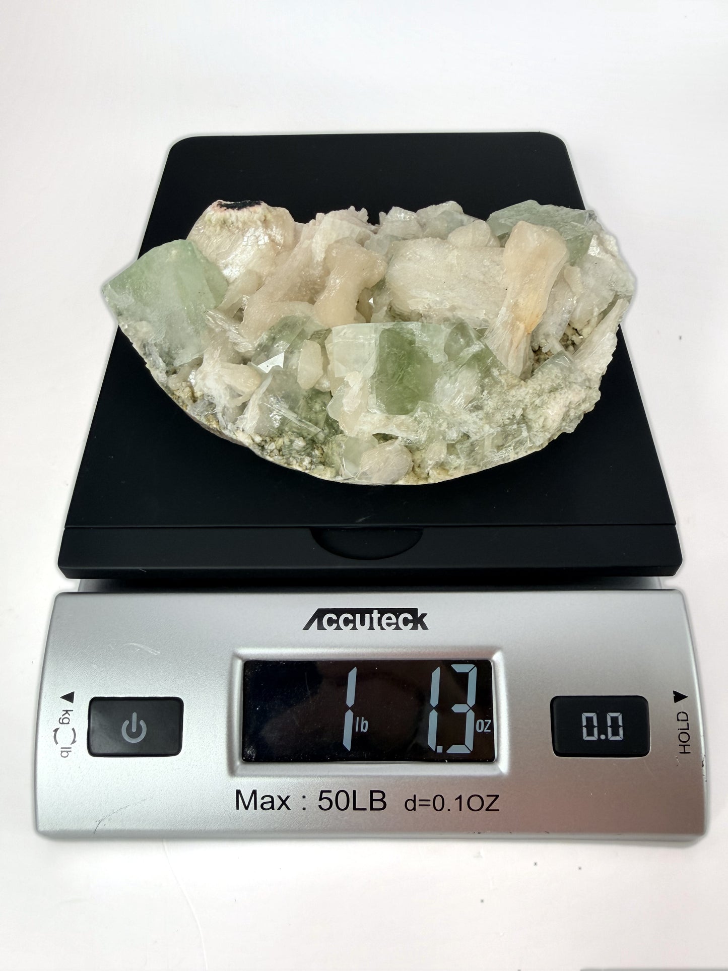 Green apophyllite with peach stilbite on a wood stand
