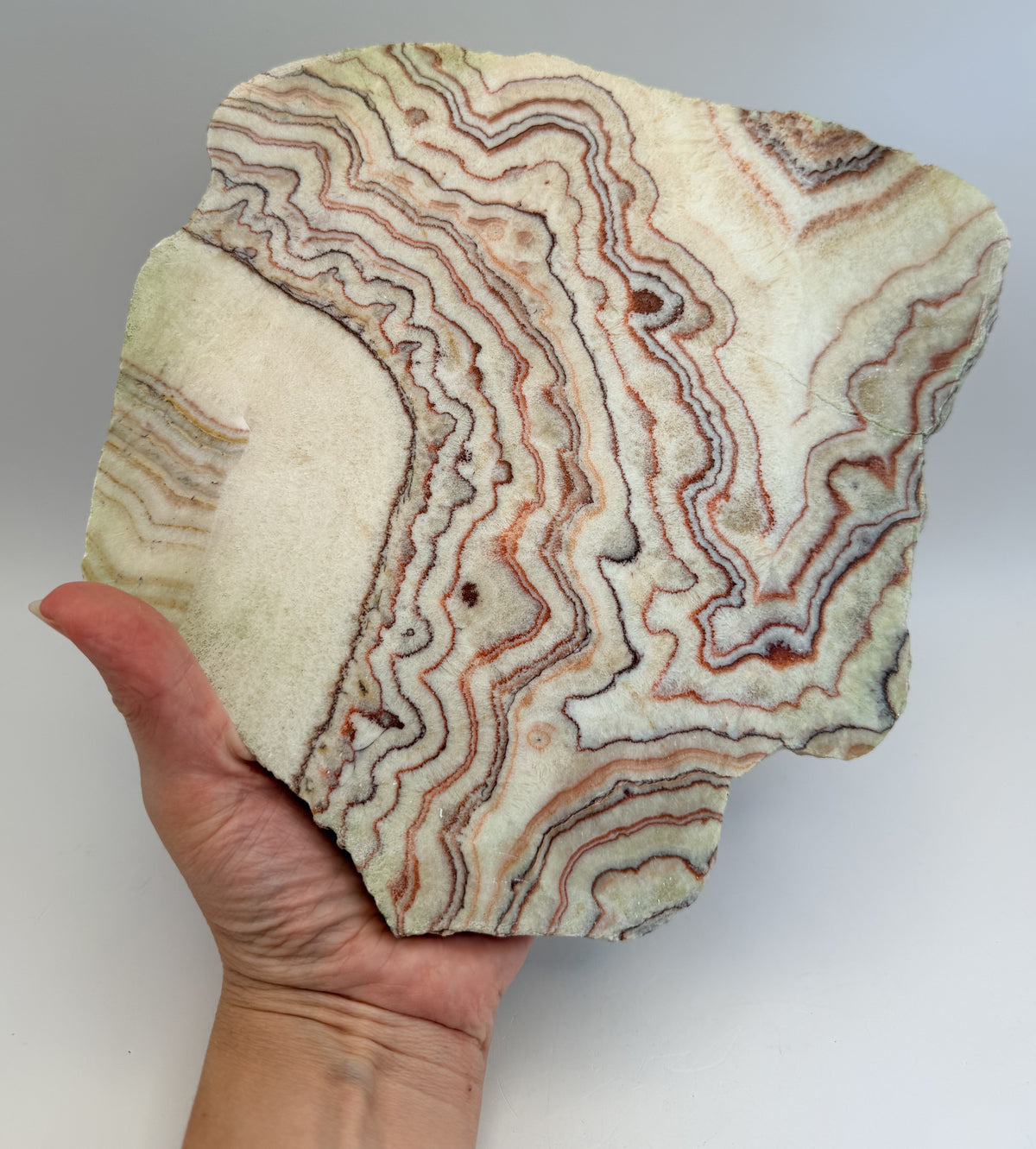 Banded calcite slab on wooden X stand