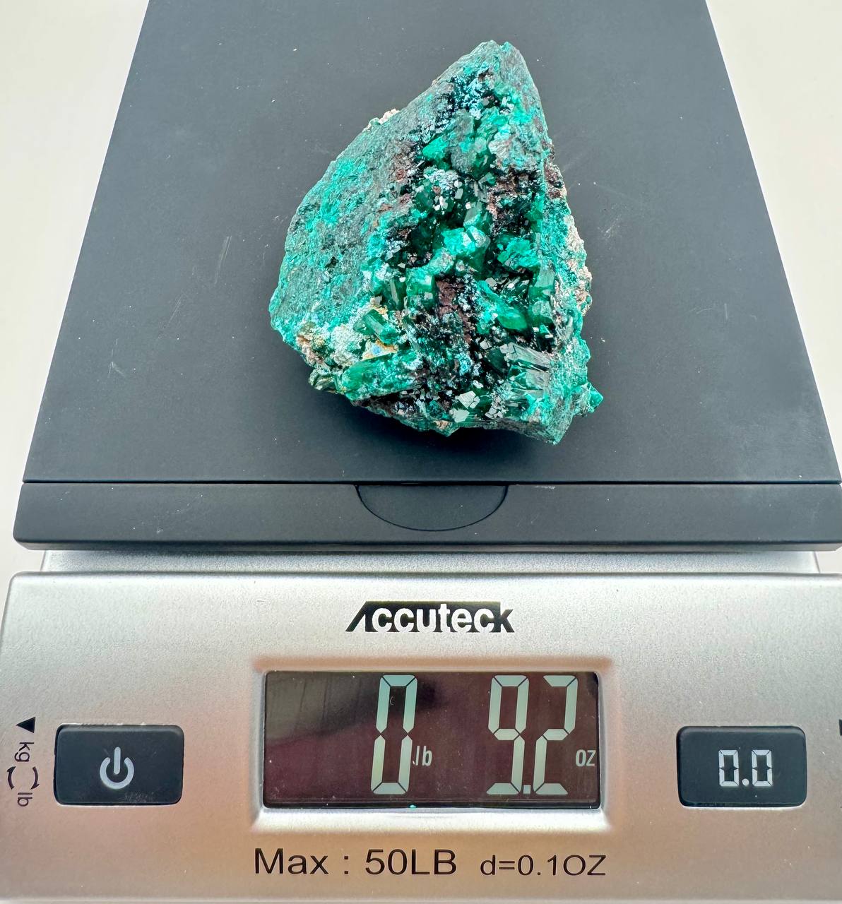 Dioptase crystal specimen on scale showing 9.2 oz