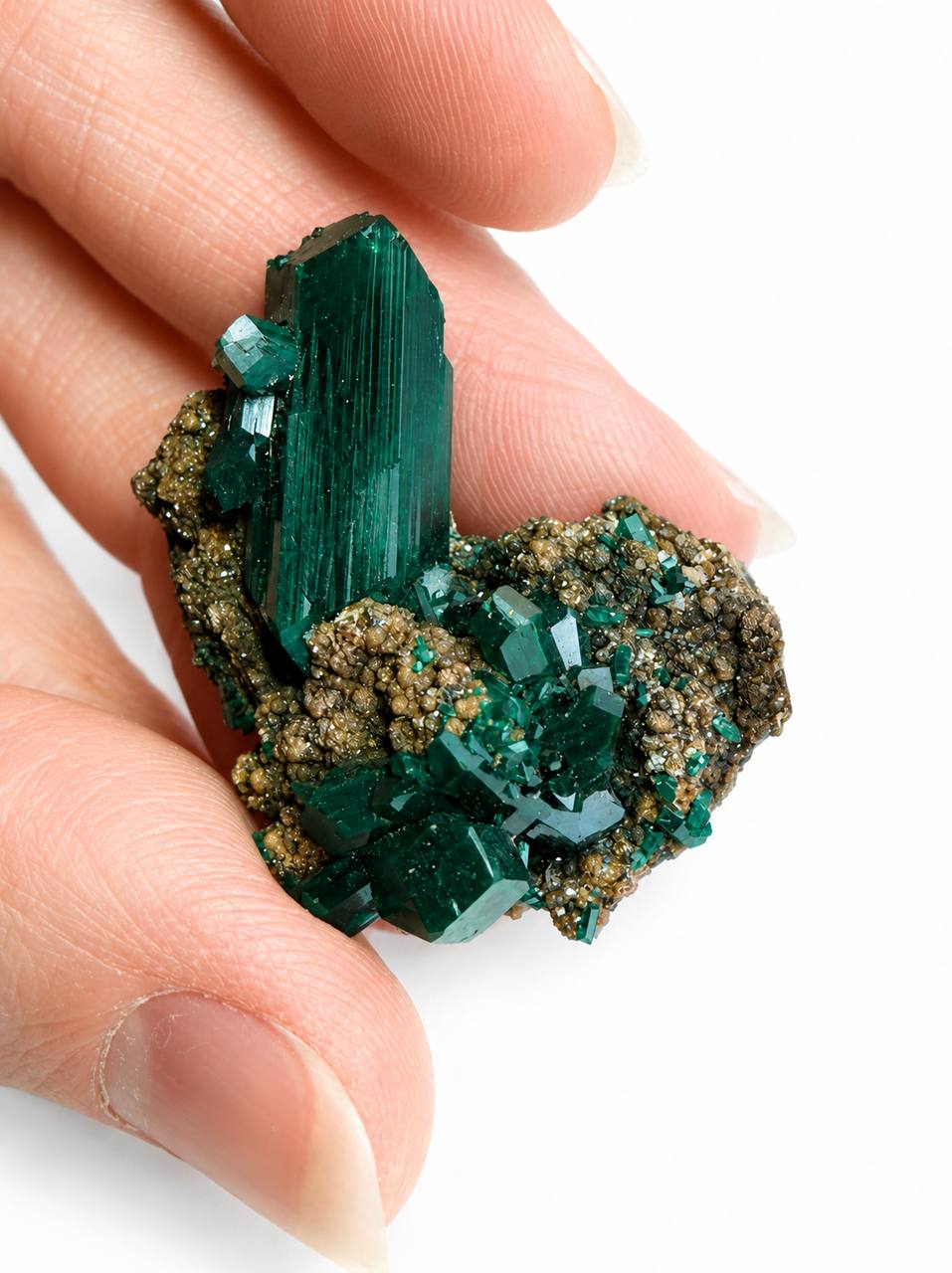 Dioptase crystal blade in hand front view showing tall prism