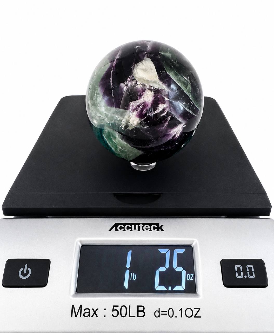 Rainbow fluorite sphere on scale showing 1 lb 2.5 oz