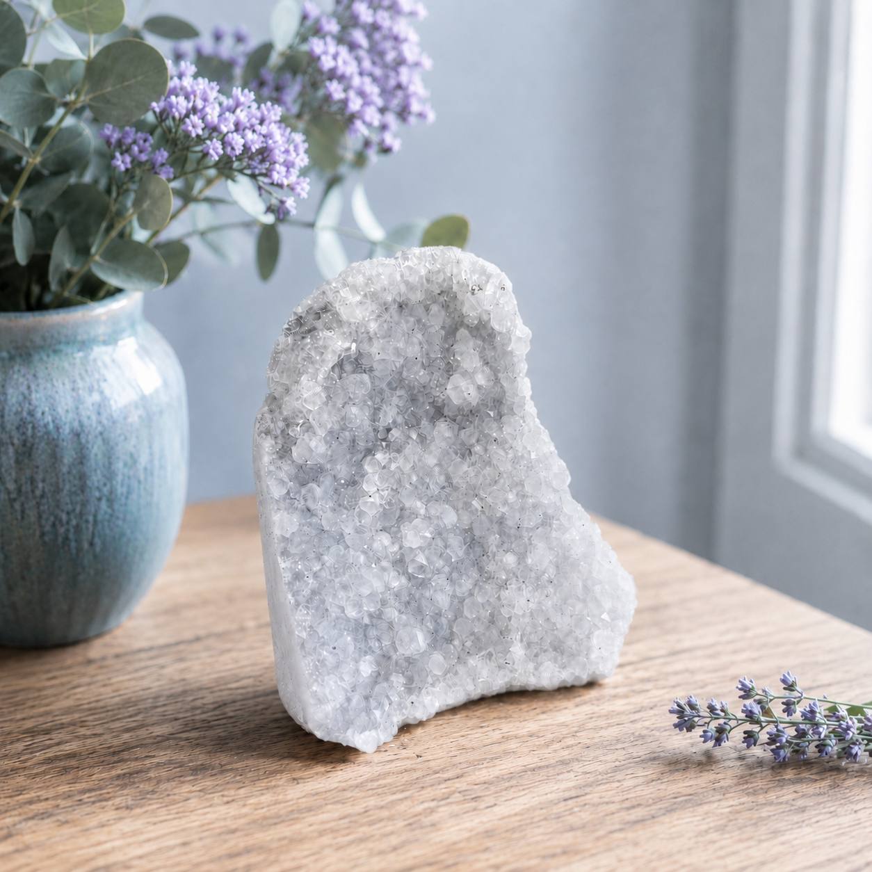 Icy amethyst crystal cluster lifestyle on oak shelf with lavender