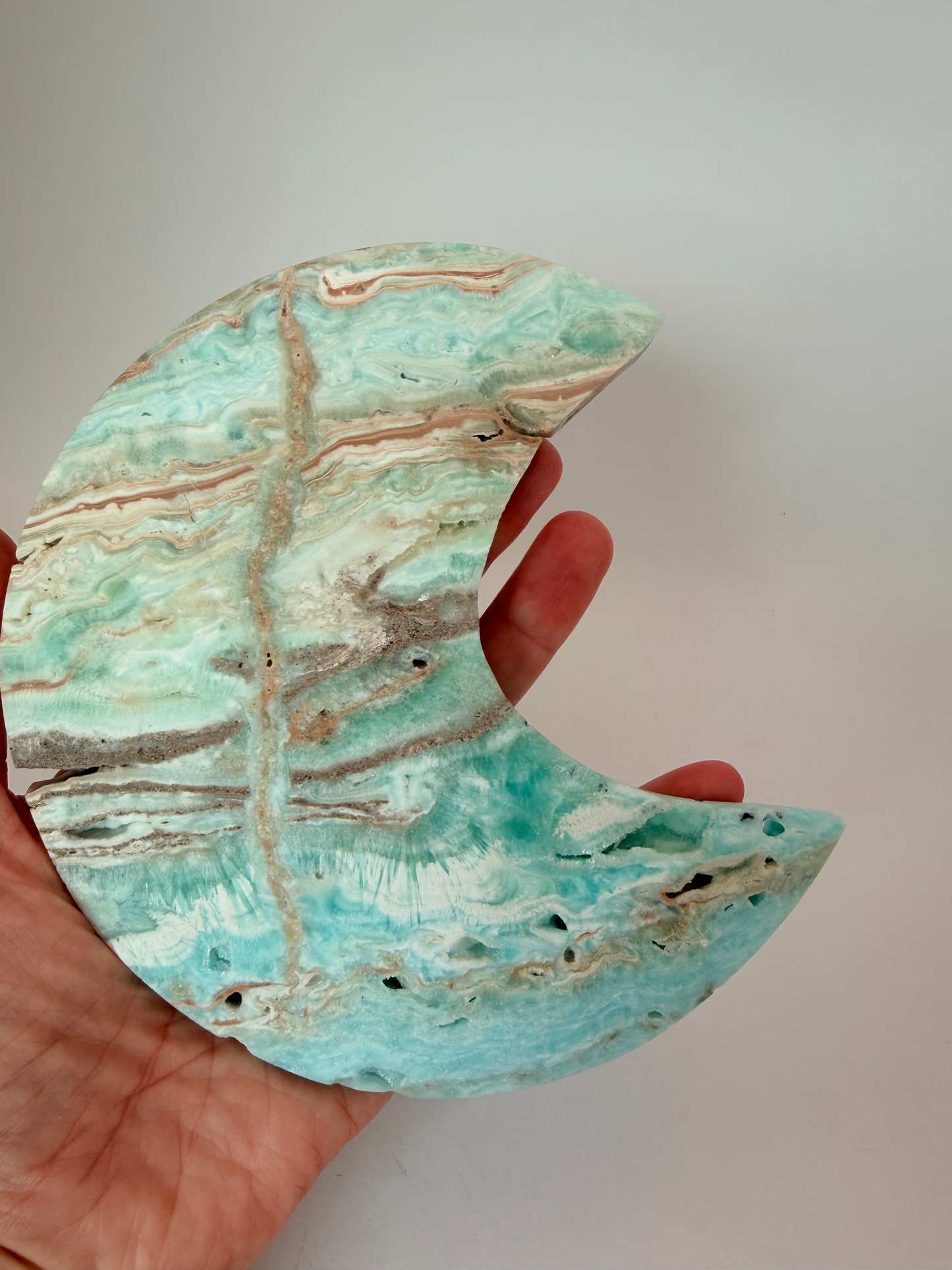 Caribbean calcite moon held in a hand for scale