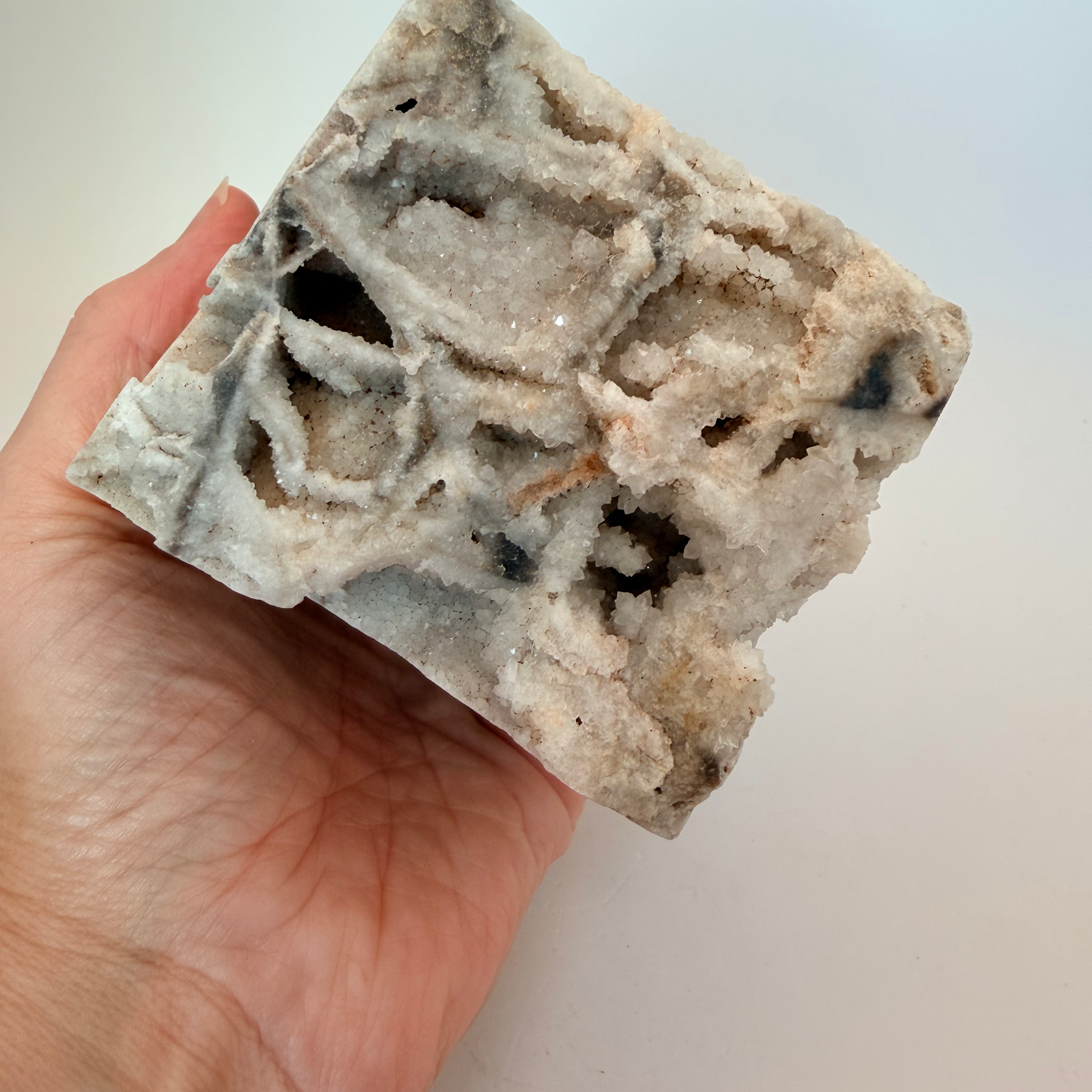 Druzy quartz boxwork specimen held in a hand for scale