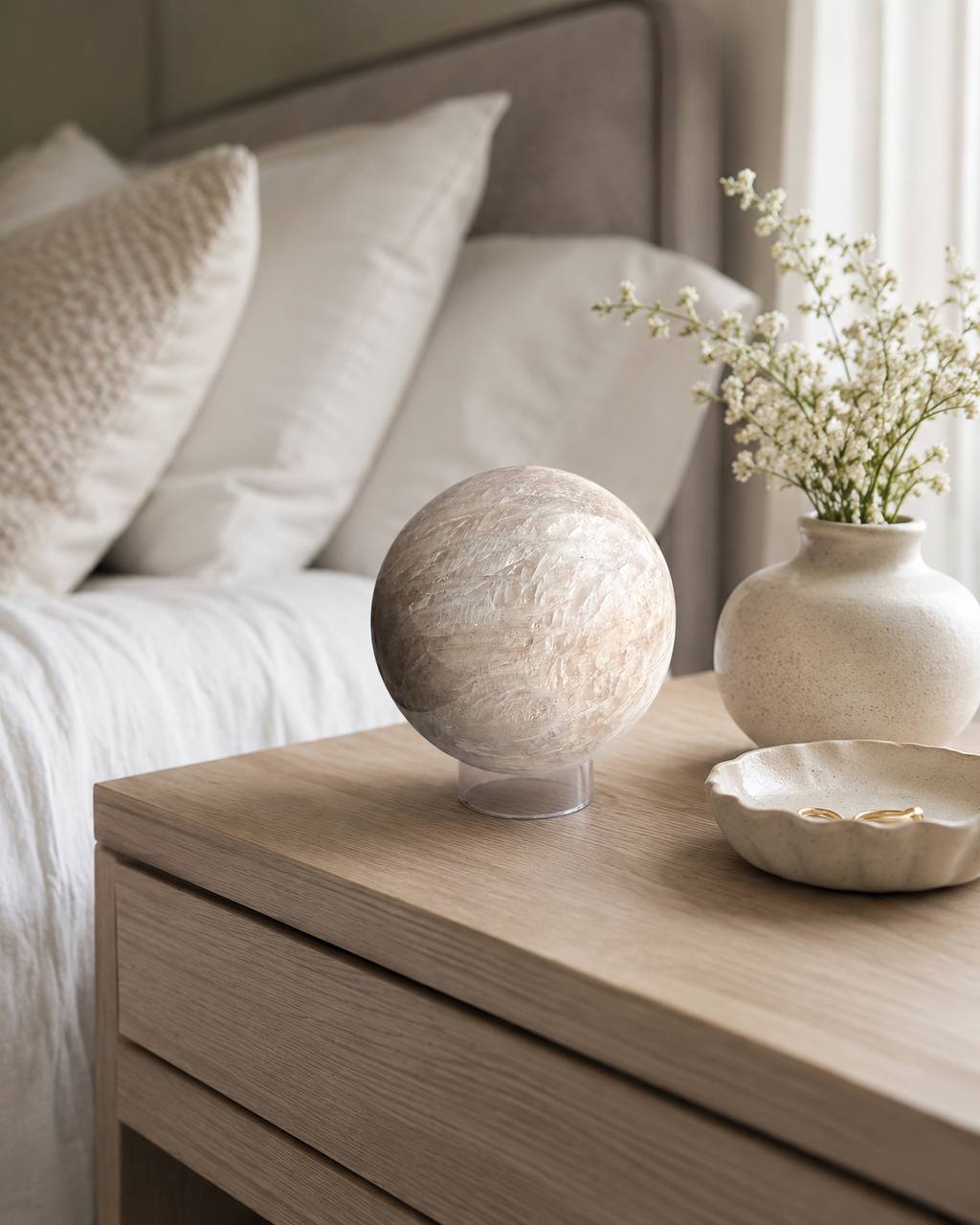 Peach moonstone sphere on bedroom nightstand with flowers