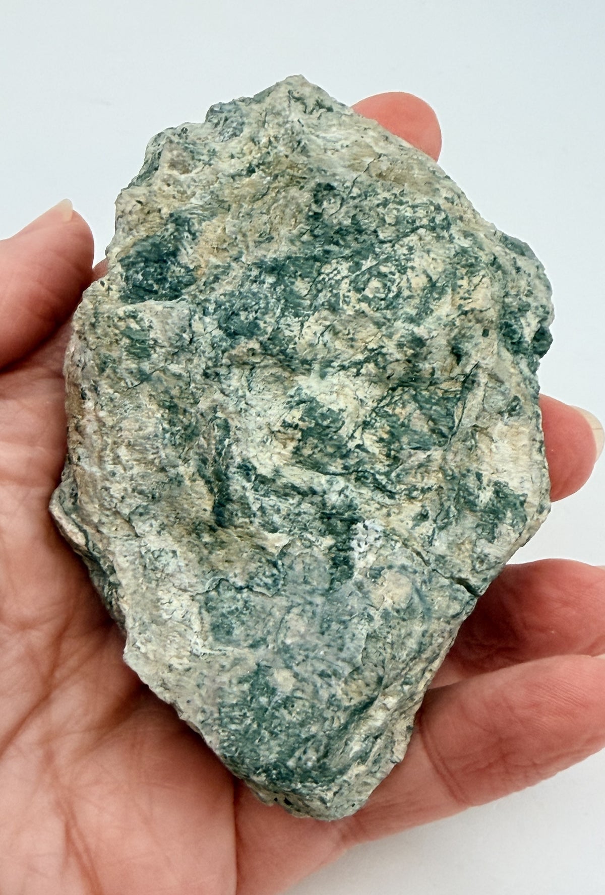 Green fluorite cluster with druzy quartz on a black display stand
