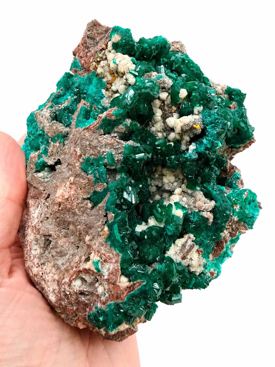 Dioptase specimen hand held showing emerald green crystals