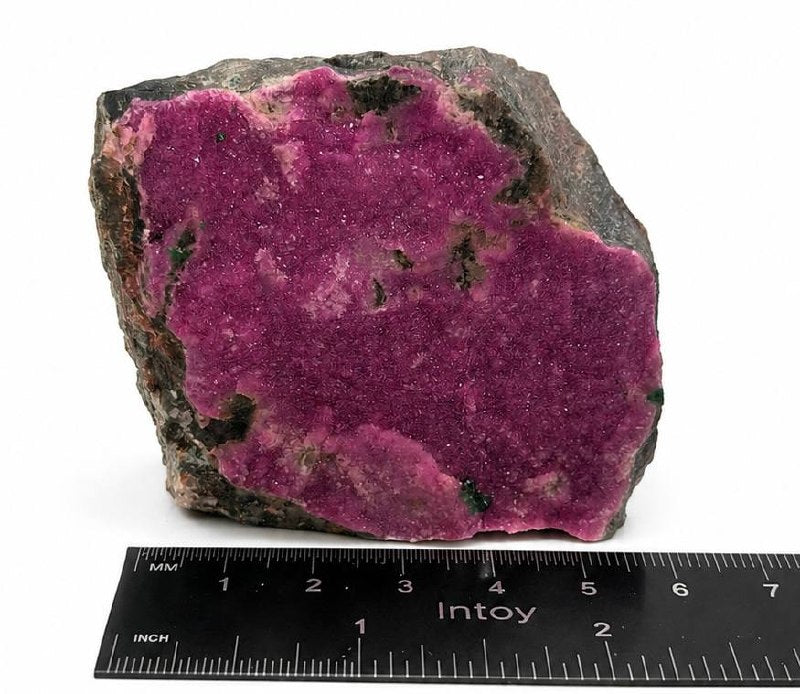 Pink cobaltoan calcite front face with ruler showing approximately 2.5 inches wide