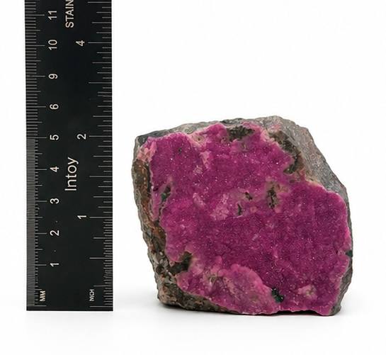 Pink cobaltoan calcite side view with ruler showing approximately 3.5 inches tall