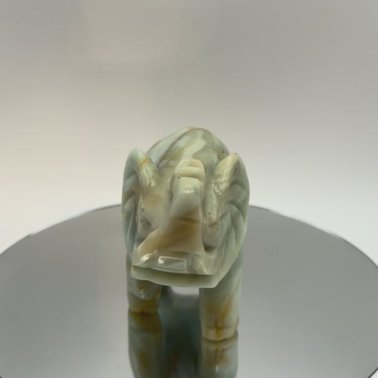 Carved banded calcite elephant turning in the light