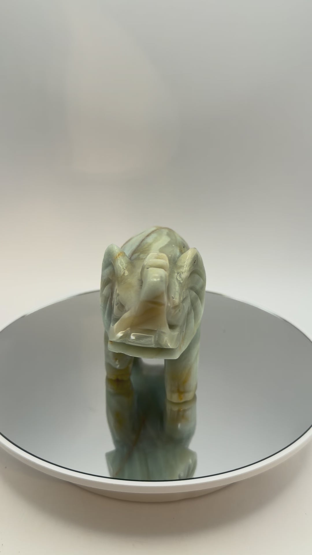 Carved banded calcite elephant turning in the light