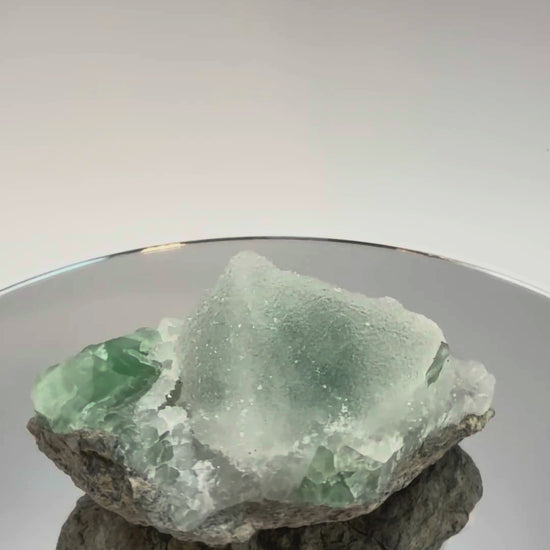 Green fluorite cluster with druzy quartz turning in the light