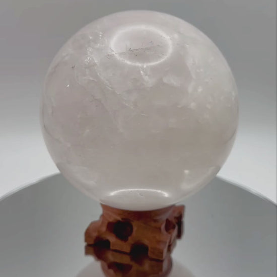 Rose Quartz Sphere rotating on wooden stand