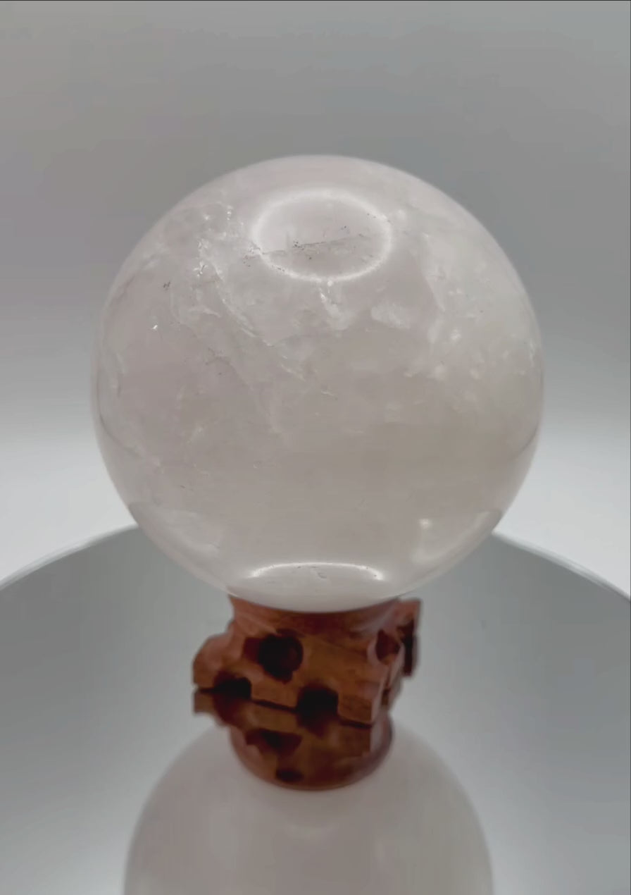 Rose Quartz Sphere rotating on wooden stand