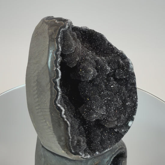 Turning the black druzy quartz geode in the light