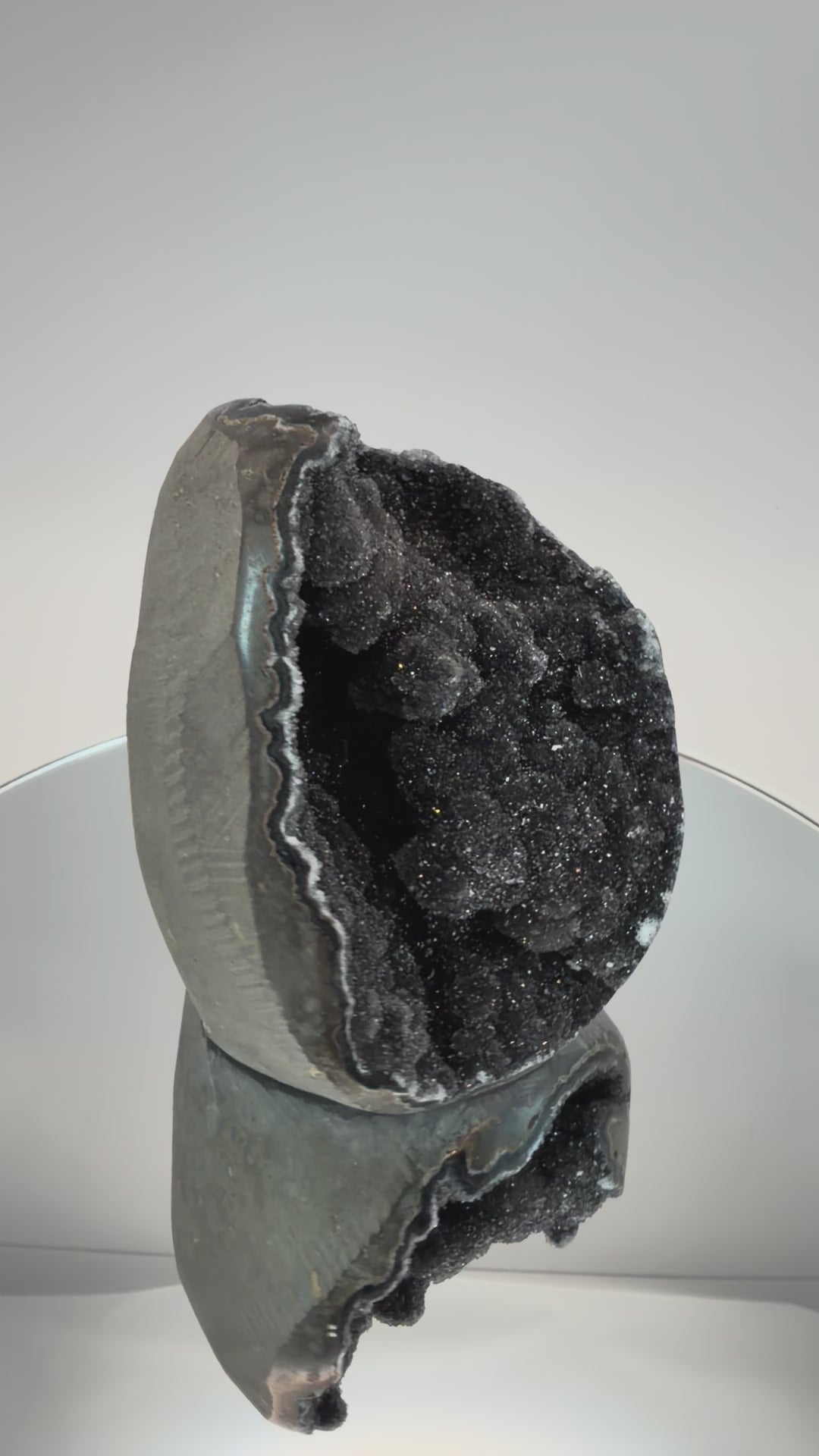 Turning the black druzy quartz geode in the light
