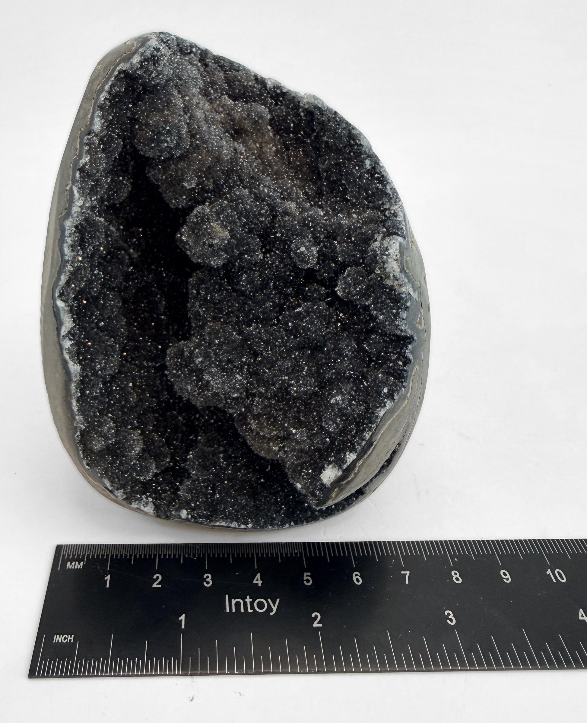 Druzy geode beside a steel ruler for width