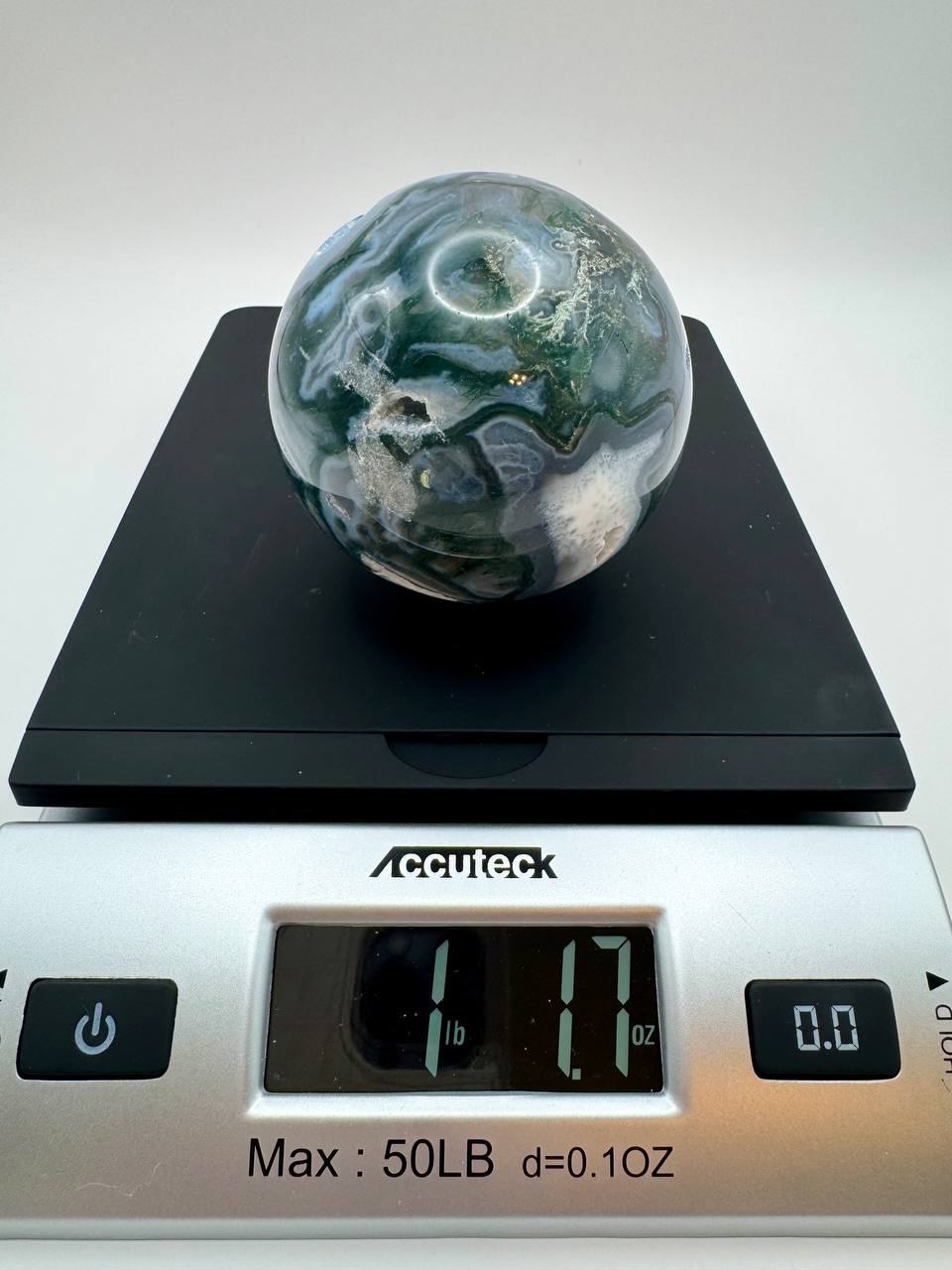Moss agate sphere on scale showing 1 lb 1.7 oz