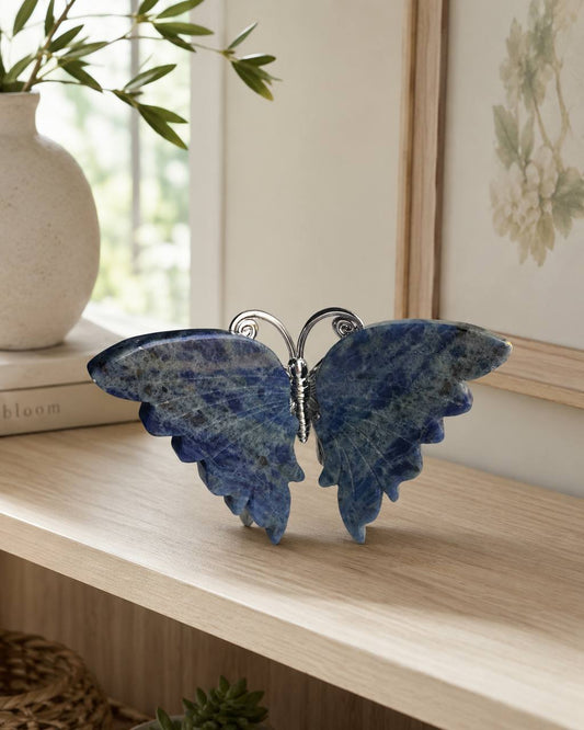 Sodalite crystal butterfly carving on wooden shelf