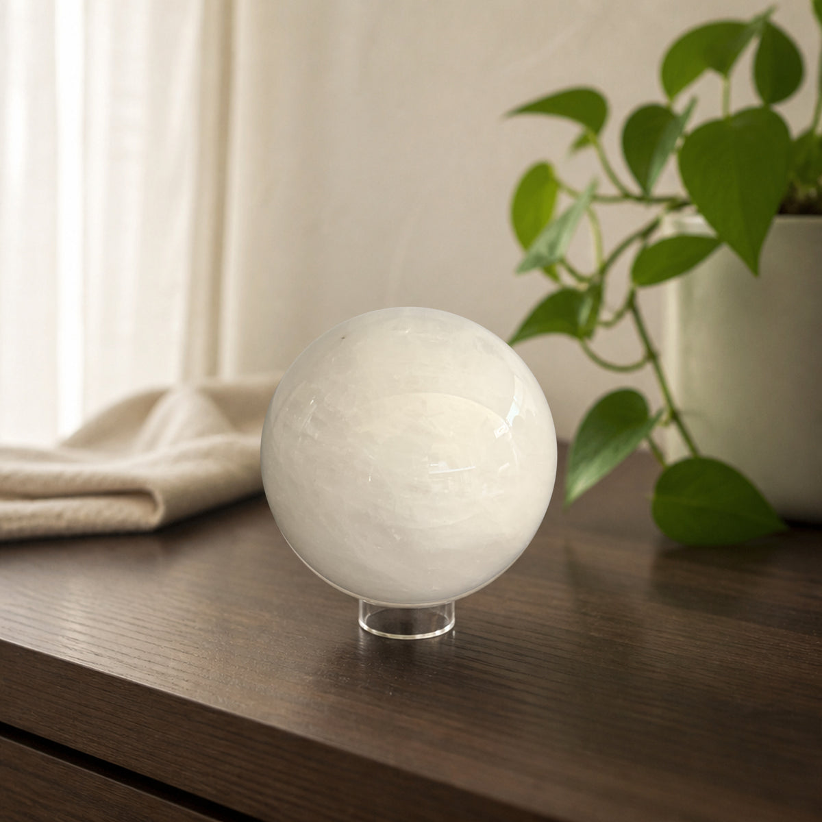 Milky quartz sphere on a walnut console