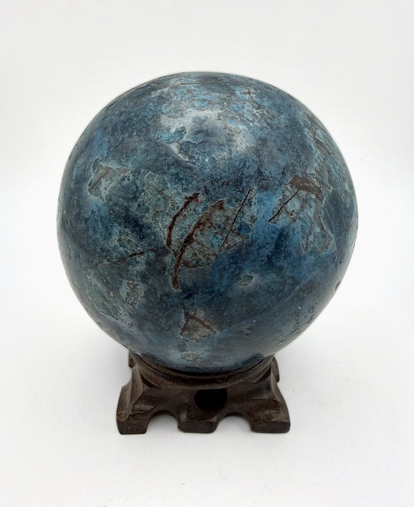 Blue apatite sphere on its carved wooden stand
