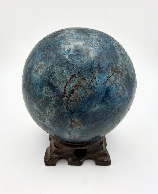 Blue apatite sphere on its carved wooden stand