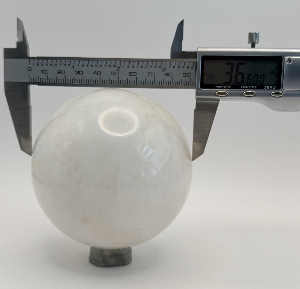Milky quartz sphere measured with calipers