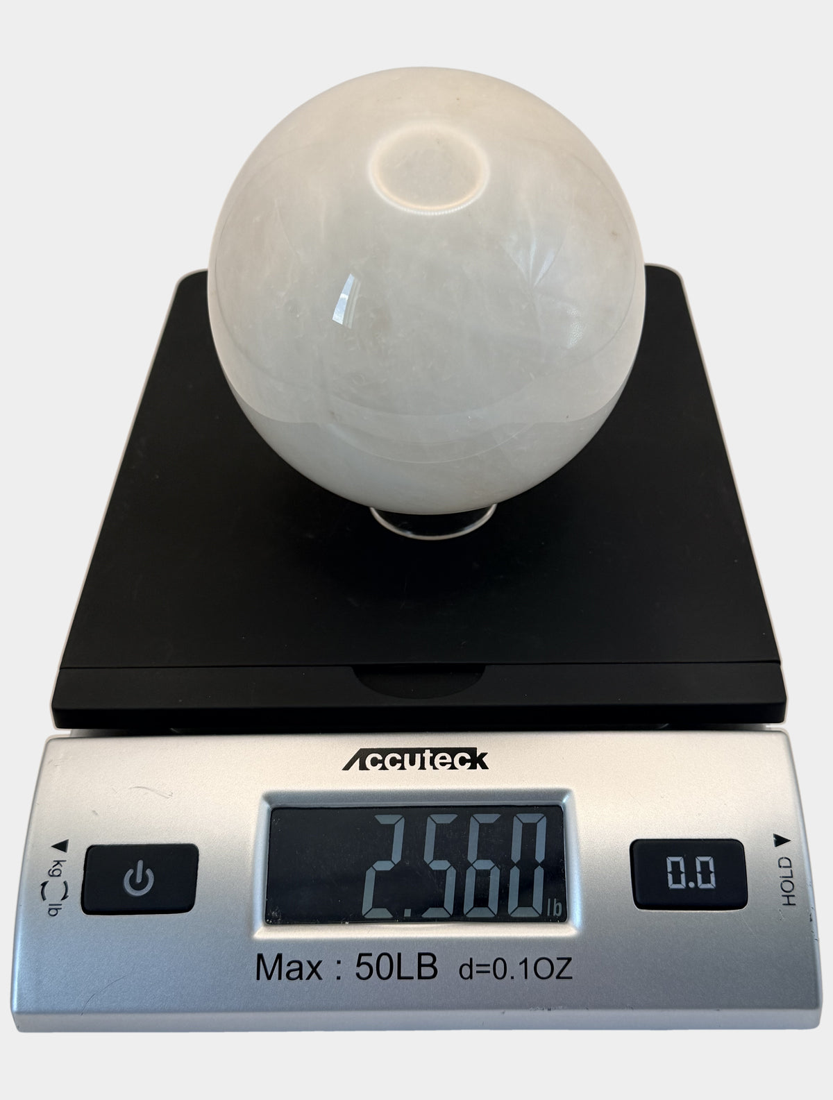 Milky quartz sphere on a scale