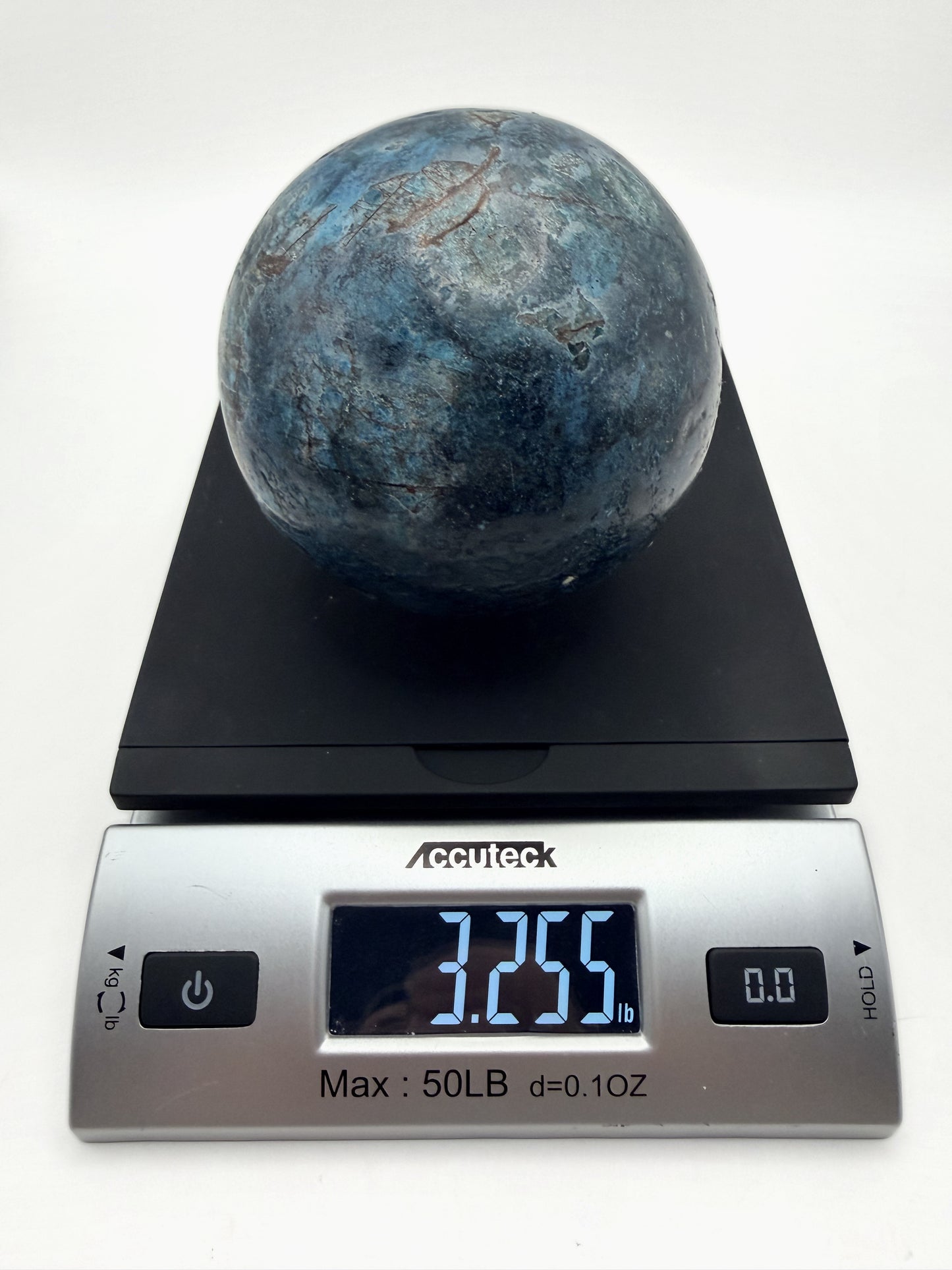 Blue apatite sphere on a scale