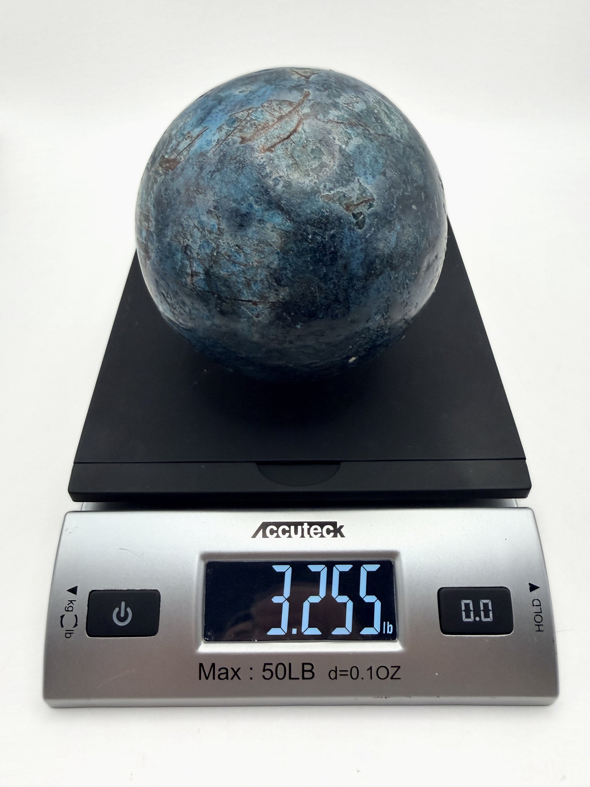 Blue apatite sphere on a scale