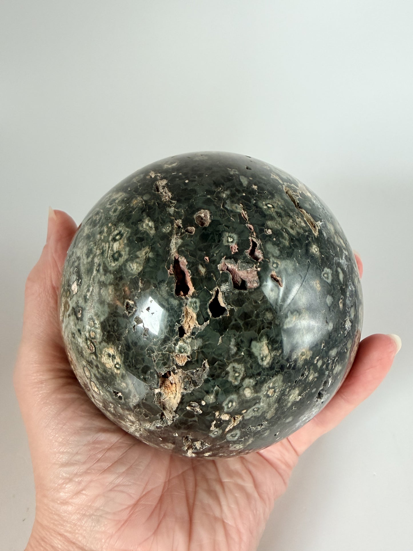 Ocean jasper sphere held in hand